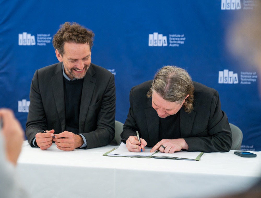 ISTA President Martin Hetzer and Garrett Camp signing the agreement on the ISTA campus.