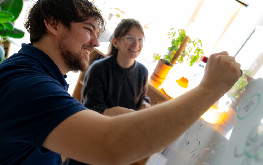 PhD‑Student Lukas Einramhof und Assistenzprofessorin Lisa Bugnet arbeiten an einem Whiteboard.